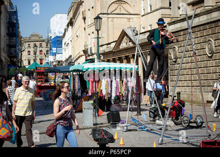 tightrope walker street entertainer on stall street Bath England UK Stock Photo