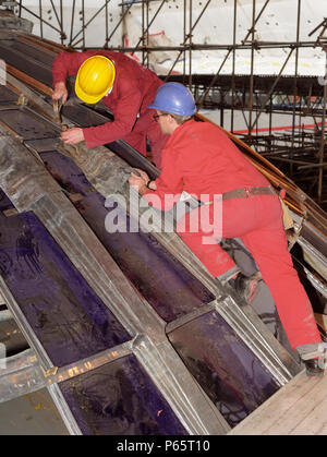 Two construction workers on a roof Stock Photo