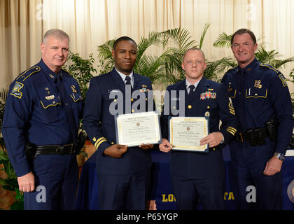 BATON ROUGE, La. - Coast Guard Lt. Jonathan Scott and Chief Petty Officer Keith Watters, (center) both members of Marine Safety Unit Baton Rouge, stand with Lt. Col. Charlie Dupuy, assistant superindendent, Louisiana State Police (left), and Col. Michael Edmonson, superintendent, LSP, after receiving an award during a ceremony at the LSP Training Academy in Baton Rouge, May 10, 2016. Scott and Watters were awarded a Louisiana State Police Meritorious Service Award for their actions on Sept. 10, 2015.  U.S. Coast Guard photo by Petty Officer 2nd Class Jonathan Lally. Stock Photo