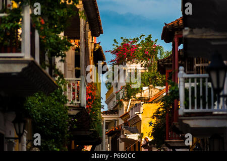 Wooden balconies, decorated with tropical flowers, are seen in the street, located in the colonial walled city in Cartagena, Colombia. Stock Photo