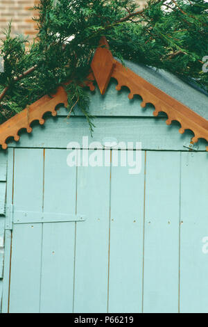 Close-up of pale blue painted garden shed with plain wood eaves Stock Photo