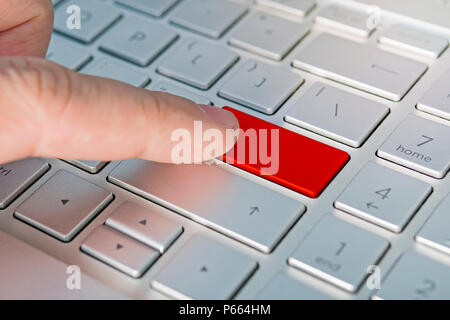 Different - grey silver keyboard with blank red button.. The man's finger presses the button. Stock Photo