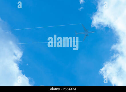 Airplane on blue sky and white clouds. Commercial airline flying on blue sky. Travel flight for vacation. Aviation transport. Stock Photo