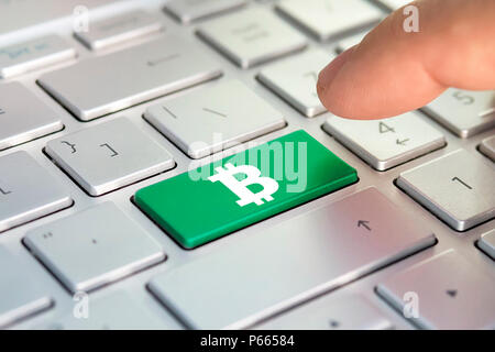 Golden bitcoin key on keyboard. Color button on the gray silver keyboard of modern ultrabook. caption on the button Stock Photo