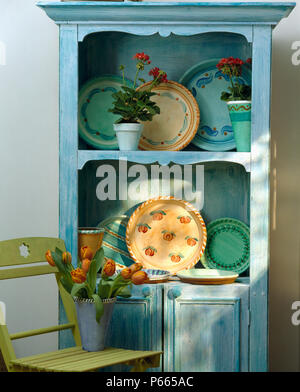 Close-up of pale blue painted dresser with hand-painted pottery plates Stock Photo