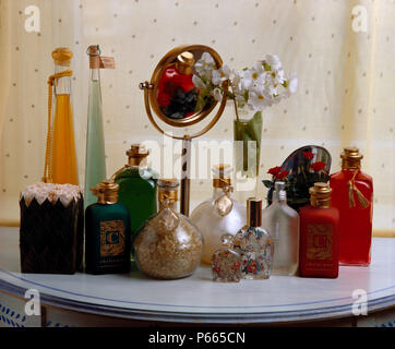 Close-up of a variety of painted and stoppered glass bottles on table with mirror on stand Stock Photo