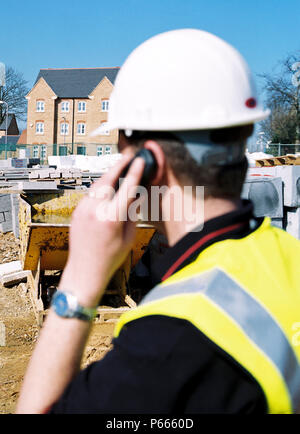 Foreman making a phone call on a building site, England Stock Photo