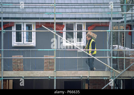 Man working on the scaffolding of a residential development. Stock Photo