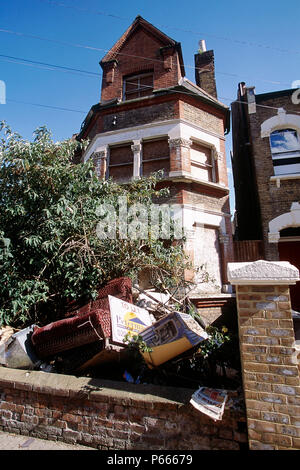 Rubbish in front garden of boarded up house. South London, United Kingdom. Stock Photo