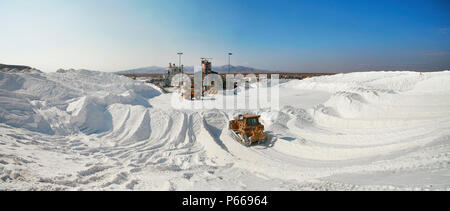 Track loaders arranging salt hills in the Salar of Atacama Stock Photo