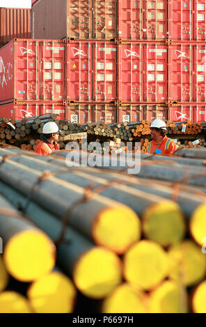Two Port Workers Talking Between Steel Bars at the Port of Mejillones Stock Photo