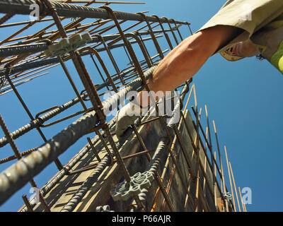 Man working on reinforced steel bar structure for reinforced concrete foundations Stock Photo