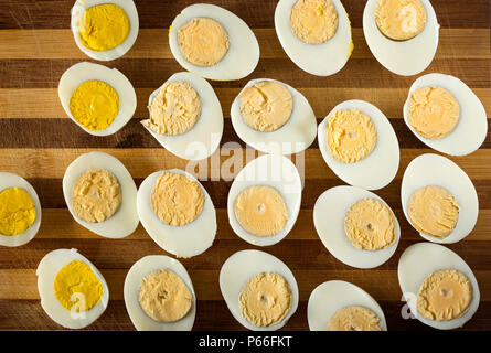 Slices of boiled hard eggs on a wooden cutting board - top view Stock Photo