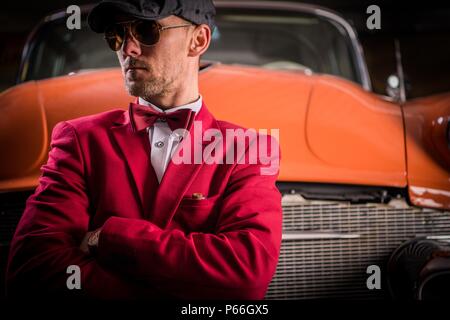 Classic Vehicles Collector. Elegant Caucasian Men Awaiting Classic Cars Auction. Stock Photo