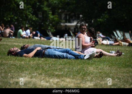People enjoy the warm weather in Green Park, London. Britons look set to enjoy the hottest temperatures of the year for the fourth day in a row this week, with the mercury predicted to soar to 32C (89.6F). Stock Photo