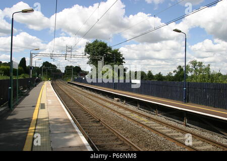 General platform view of Berkswell station, Warwickshire showing overhead electric catenary and platform lighting. 2007 Stock Photo