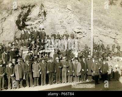 Last Deadwood Coach. The last trip of the famous Stage 1890 by John C. H Grabill, photographer. Barely visible stagecoach surrounded by large group of men, in front of cliff. Stock Photo