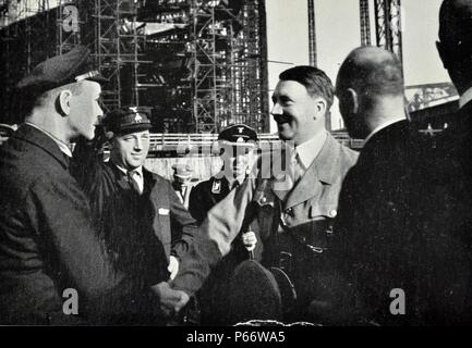 Adolf Hitler visits the Blohm & Voss the shipbuilding and engineering works. The company built aircraft through Hamburger Flugzeugbau before and during World War II. Germany's rearmament in violation of the Versailles Treaty meant a big change in fortune for the company, run then by brothers Rudolf and Walther Blohm, which was taken out of a deep crisis. From July 1944 to April 1945 the company used inmates of its own concentration sub camp at its shipyard in Hamburg-Steinwerder, a sub camp of Neuengamme concentration camp. Stock Photo