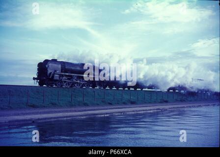 Against the wind. Re-built ex Southern Railway Bulleid Merchant Navy Class Pacific No.35008 Orient Line speeds across the lake at Poole with an up tra Stock Photo