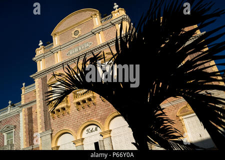 A palm tree is seen in front of Teatro Heredia, a theatre located in the colonial walled city of Cartagena, Colombia. Stock Photo
