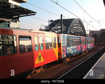 The advertising liveries of Tyne & Wear Metro give some variety as seen at St Peters when the leading set, bearing an advertising livery, compares to  Stock Photo