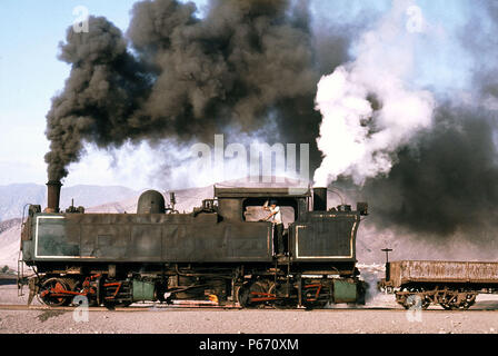 This view of the last Kitson Meyer at Taltal in Chile's Atacama Desert shows the two chimneys, the front one issuing pulls of oil smoke and the rear o