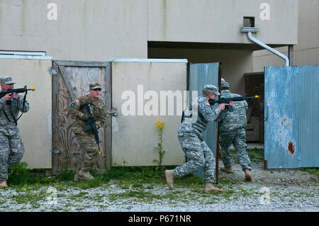 Soldiers of the 377th Detachment, 377th Company, and 377th Battalion out of Cincinnati, Ohio, tactically move to clear a house during a Situational Training Exercise at Muscatatuck Urban Training Center, Ind., May 14th 2016. The training is part of the 377th Detachment, 377th Company, and 377th Battalion Battle Assembly to test the MPs knowledge and ability to react to realistic scenarios they may encounter in a deployed environment. (Photo by US Army Sgt. Marco Gutierrez.) Stock Photo