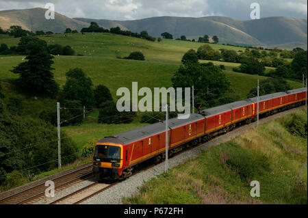 A southbound postal train comprived of a 325 class EMU passes Grayrigg village between Tebay and Oxenholme in the summer of 2003. Stock Photo