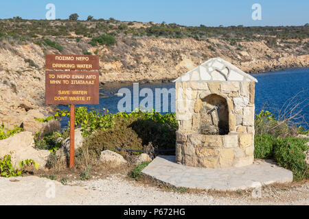 Public water drinking fountain with a warning sign about not wasting water near Korakas Bridge, Cyprus Stock Photo