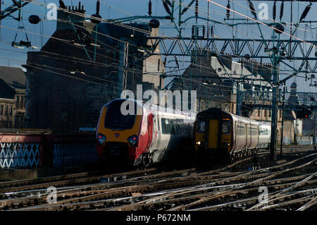 A Virgin Voyager departing on a service to Plymouth passes a local service from Edinburgh via Shotts on the approaches to Glasgow Central. November 20 Stock Photo