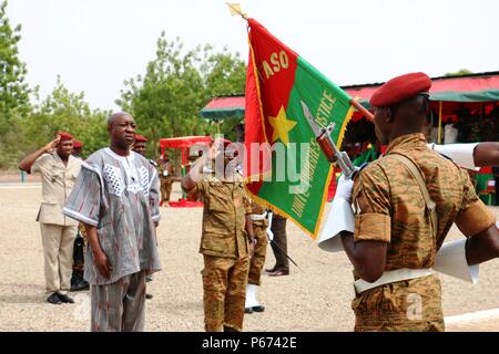 Burkina Faso Prime Minister Paul Kaba Thieba (left) and General Pingrenoma Zagre (center), Chief of Defense Staff for Burkina Faso Armed Forces, honor the Burkina Faso national flag during the Western Accord 2016 Closing Day Ceremony May 13, 2016 at Camp Zagre, Ouagadougou, Burkina Faso. The two-week command post exercise, which began May 2, brought together 15 West African Nations, 7 NATO European countries and the U.S. to work as a multinational headquarters to build interoperability and shared understanding. (U.S. Army photo by Staff Sgt. Candace Mundt/Released) Stock Photo