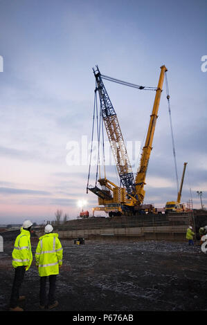 Construction engineers watching crane working on Upper Forth Crossing, Scotland Stock Photo