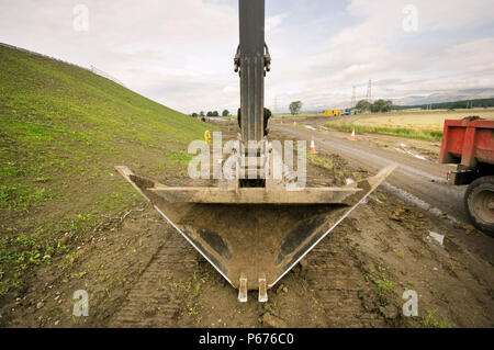 A trapezoidal excavator bucket for digging drainage ditches Stock Photo