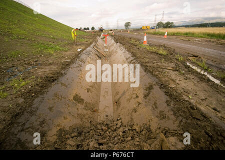 Drainage ditch dug out by a trapezoidal excavator bucket Stock Photo