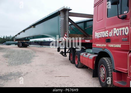 Special vehicles required to transport composite bridge sections to the site Stock Photo