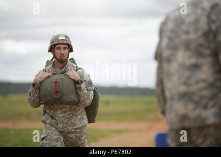 Spc. Jay Flannery from 2nd Battalion, 508th Parachute Infantry Regiment, 2nd Brigade Combat Team, 82nd Airborne Division walks off Sicily Drop Zone after performing a static line jump during the Saturday Proficiency Jump Program (SPJP) at Fort Bragg, North Carolina on May 21, 2016. The SPJP builds proficiency, experience, and confidence of individual Paratroopers, ensuring the XVIII Airborne Corps and 82nd Airborne Division remain ready for contingency response missions. (US Army Photo by Sgt. Tierney P. Curry)(Released) Stock Photo