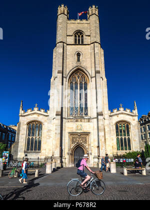 Cambridge Tourism - cyclists pass Great St Mary's church in central Cambridge. The church, rebuilt after a fire in 1290, is Cambridge University Churc Stock Photo
