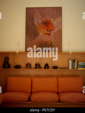 View of an artistic painting above a colorful couch Stock Photo