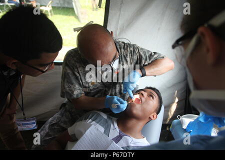 U.S. Army Maj. John Endow with the 185th Dental Company evaluates a patient teeth and checks for cavities during a medical readiness exercise at San Padro, Guatemala, May 10, 2016.  Task Force Red Wolf and Army South conducts Humanitarian Civil Assistance Training to include tactical level construction projects and Medical Readiness Training Exercises providing medical access and building schools in Guatemala with the Guatemalan Government and non-government agencies from 05MAR16 to 18JUN16 in order to improve the mission readiness of US Forces and to provide a lasting benefit to the people of Stock Photo