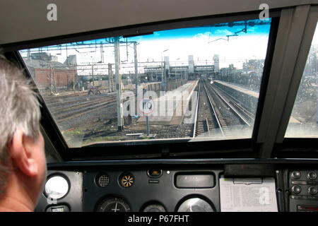 Driver's eye view from the cab of a Virgin Trains Class 90 electric locomotive approaching a station on the West Coast Main Line between Scotland and  Stock Photo