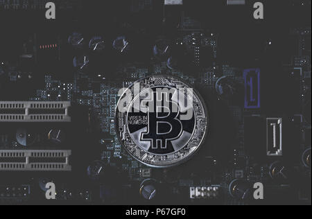 Real silver bitcoin  on dark toned integrated circuit background Stock Photo