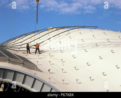 Two construction workers receive building material from a crane lift on the roof of the Sage Music Centre, Gateshead, Newcastle. Stock Photo