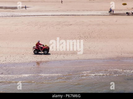 Life guard patrolling the beach on a quad bike at Saltburn by the Sea, England,UK Stock Photo