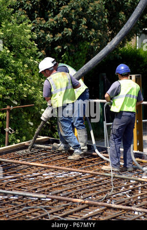 Construction workers pouring concrete Stock Photo
