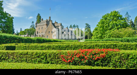 CAWDOR CASTLE NAIRN SCOTLAND  MAIN BUILDING AND MINOTAUR WITH RED SCOTTISH FLAME FLOWERS ON THE MAZE HEDGE Stock Photo