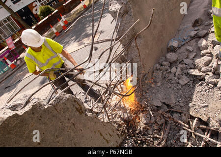 Cutting through re-inforcement bars during the dismantling a section of footbridge Stock Photo