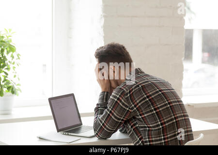 Depressed worker feeling down being fired via email Stock Photo
