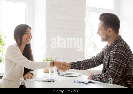 Smiling partners handshaking after successful work negotiations Stock Photo
