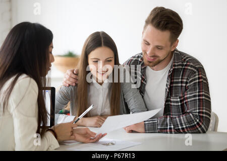 Female realtor consulting millennial spouse on property buying Stock Photo