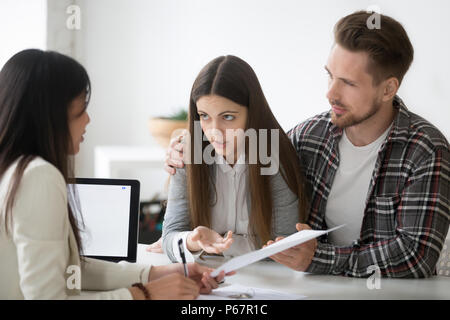 Young spouses having dispute about house buying with realtor Stock Photo